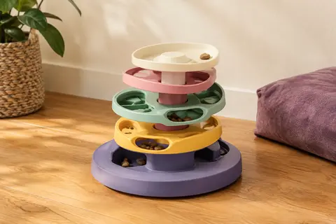Labyrinthe d’alimentation Catit multicolore posé sur un sol en bois dans un intérieur chaleureux